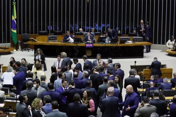 Deputados em pé no Plenário da Câmara estão conversando