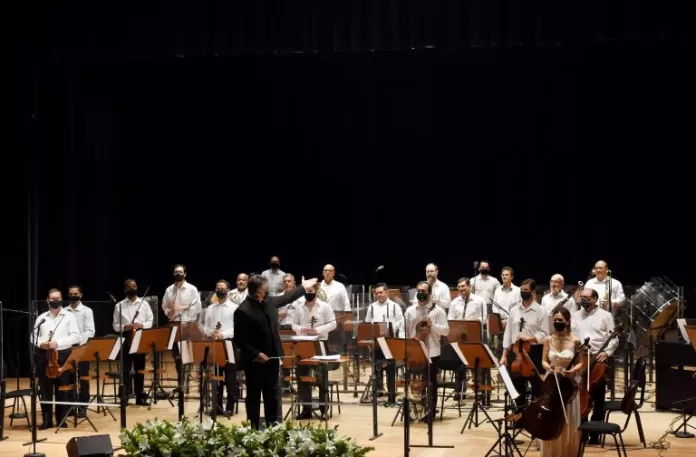 Orquestra sinfônica se apresenta num palco 