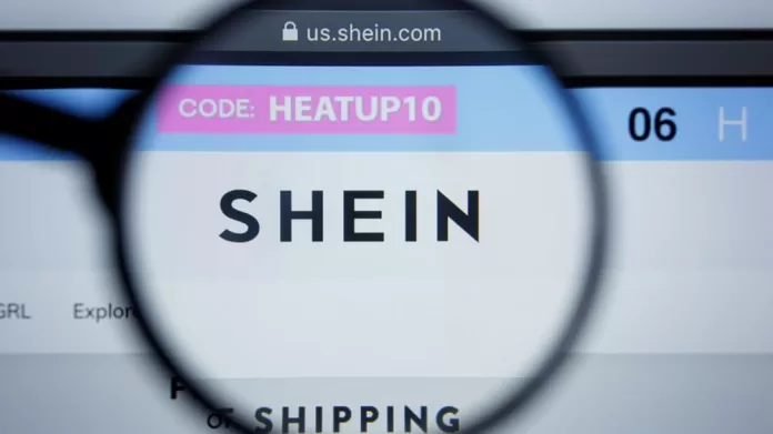 Homepage da Shein aberta em computador com lupa em cima