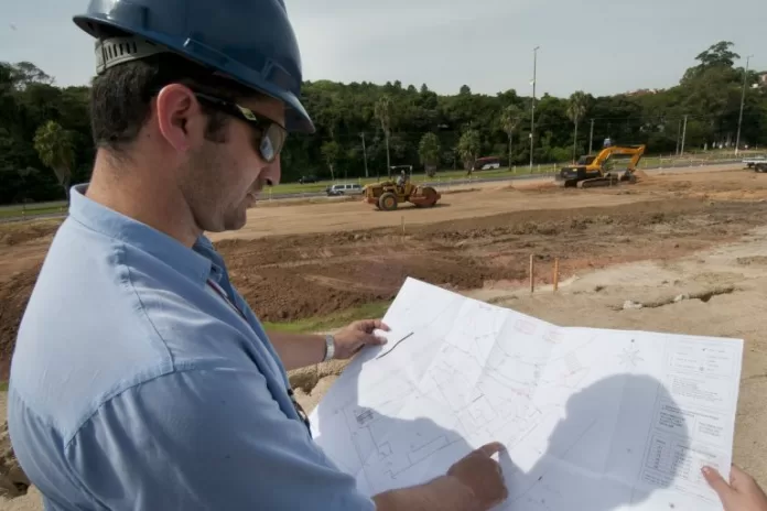 Engenheiro lê planta de obra