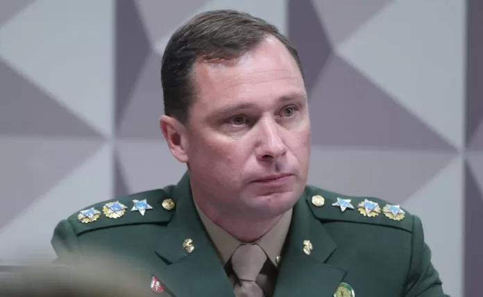 Tenente Coronel, Mauro Cid, é um homem claro usa uniforme do Exército e está calado olhando para frente.