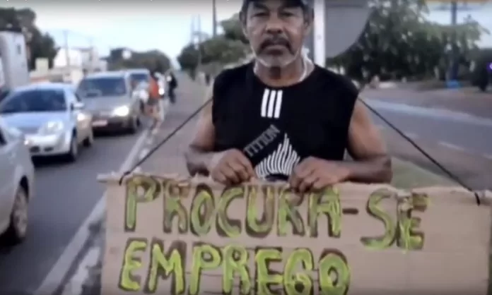 Homem segura um cartaz escrito: procura-se emprego