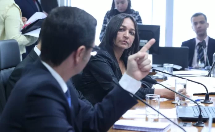 A senadora Eliziane Gama está sentada à mesa