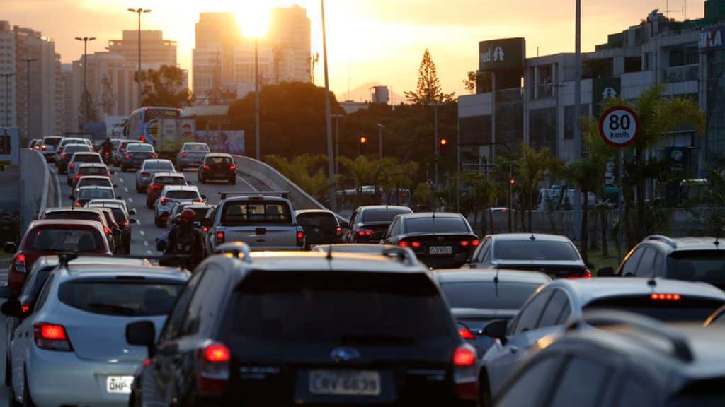 Carros em avenida durante pôr-do-sol