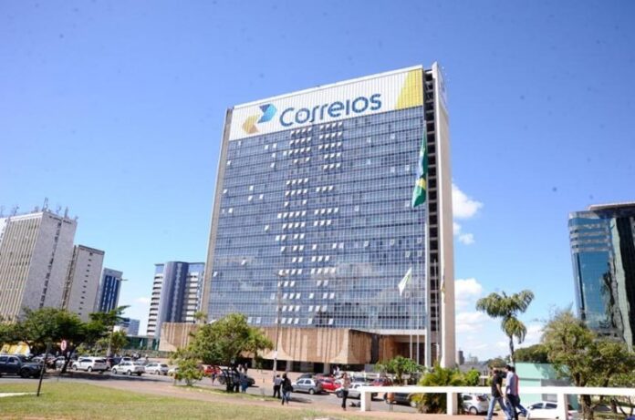 Um prédio espelhado com um letreiro bem no alto escrito: Correios