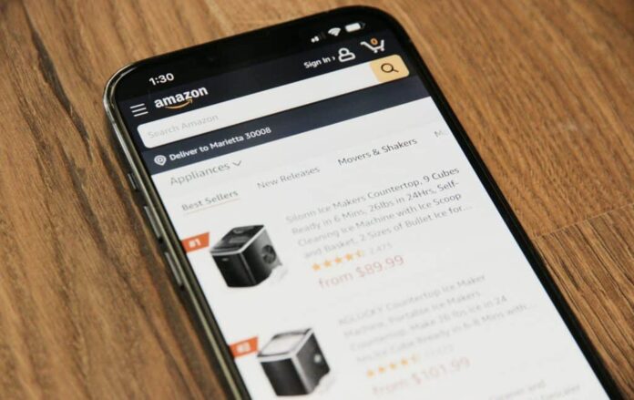 imagem mostra uma pessoa usando o app de celular da amazon para fazer uma compra online