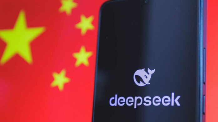 Celular com logotipo da DeepSeek na tela colocado na frente de tela exibindo bandeira da China