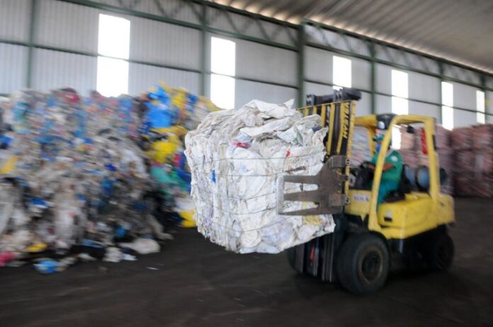 Galpão de reciclagem - resíduos sólidos compactados sendo organizados