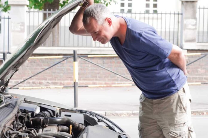 Homem verificando a bateria do carro