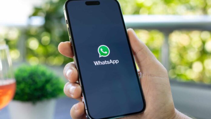 Logo do WhatsApp em um smartphone segurado por uma pessoa