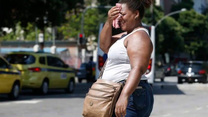 Mulher secando suor do rosto em dia quente no Rio de Janeiro