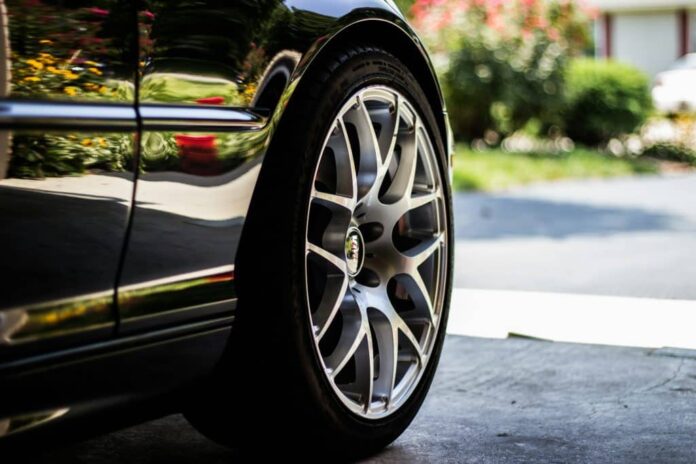 imagem mostra o close up da região traseira de um carro, com foco numa das rodas