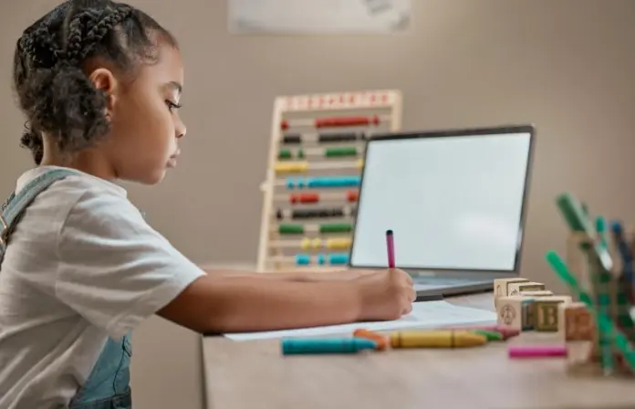Criança usa computador para estudar