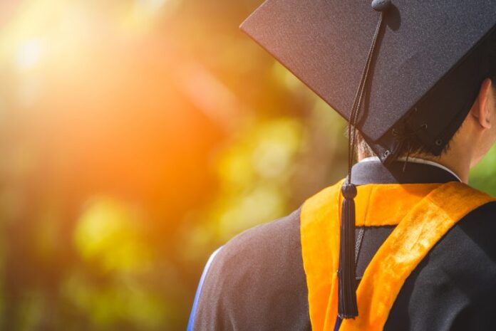 Aluno de costas vestindo roupa de fornatura no ensino superior